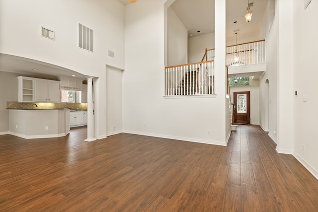 15106 Aragon Green Dr, Cypress, TX 77433 - unfurnished living room featuring dark wood finished floors, a high ceiling, baseboards, and a chandelier