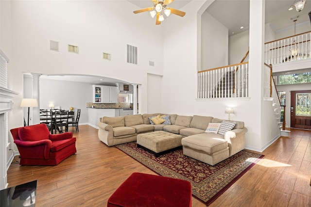 15106 Aragon Green Dr, Cypress, TX 77433 - living room with ceiling fan, stairway, a high ceiling, wood finished floors, and baseboards