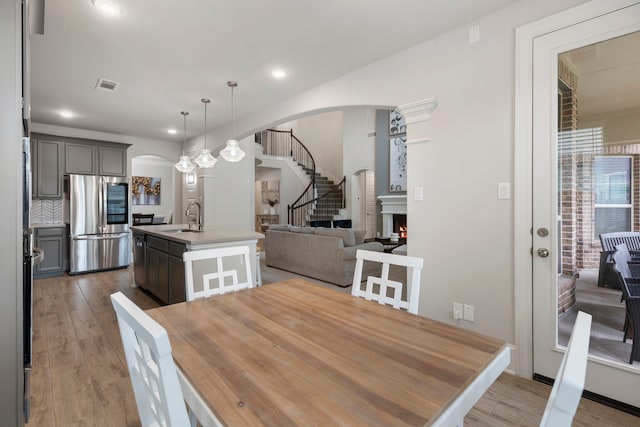 17505 Spice Merlot Ln, Conroe, TX 77302 - dining area featuring arched walkways, light wood finished floors, recessed lighting, and stairway