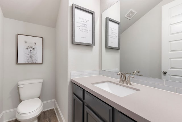 17505 Spice Merlot Ln, Conroe, TX 77302 - half bathroom with wood finished floors, toilet, vanity, lofted ceiling, and baseboards