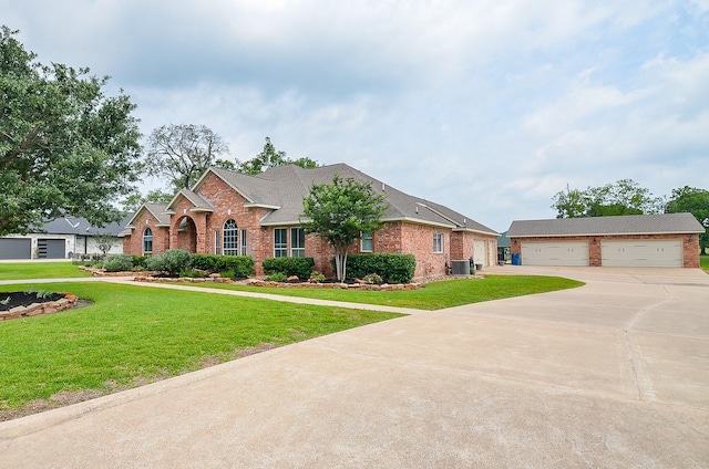 320 Eagle Cv, Hempstead, TX 77445 - traditional-style home with brick siding, central AC, a detached garage, and a front lawn