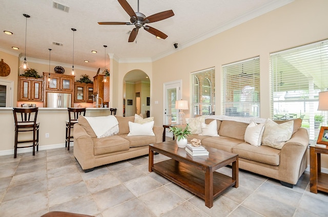 320 Eagle Cv, Hempstead, TX 77445 - living room with arched walkways, a ceiling fan, ornamental molding, baseboards, and light tile patterned flooring