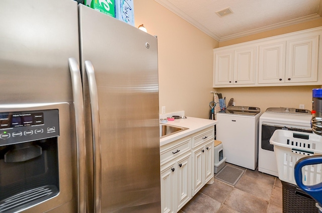320 Eagle Cv, Hempstead, TX 77445 - laundry room with washing machine and dryer, cabinet space, and ornamental molding