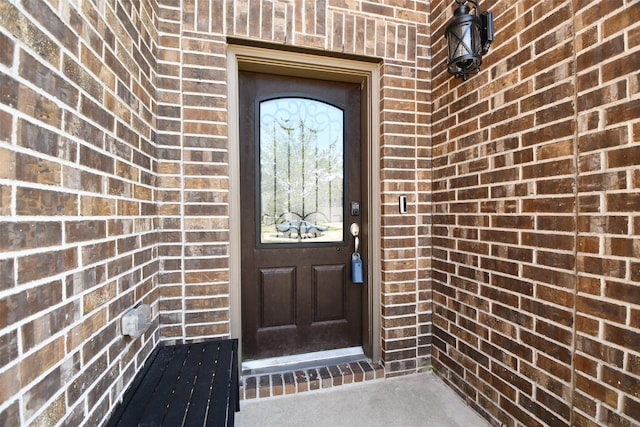 property entrance featuring brick siding