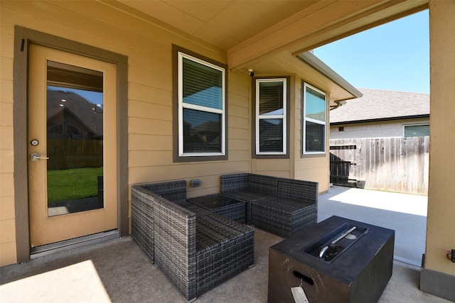 view of patio with an outdoor living space with a fire pit