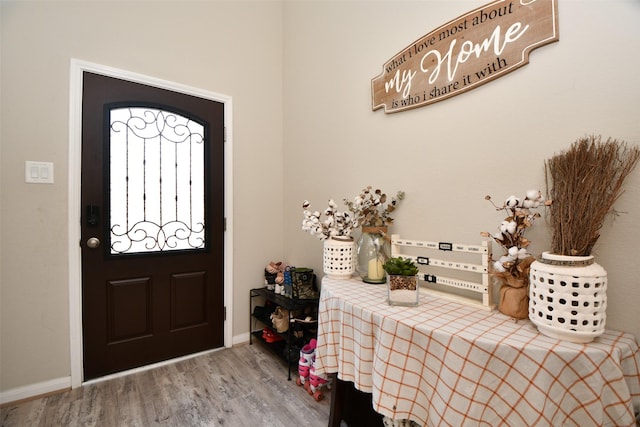 foyer entrance with wood finished floors and baseboards