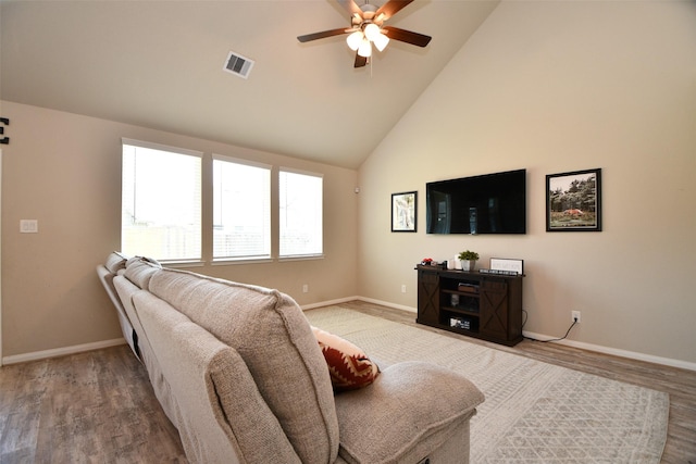 living area featuring a ceiling fan, baseboards, wood finished floors, and high vaulted ceiling
