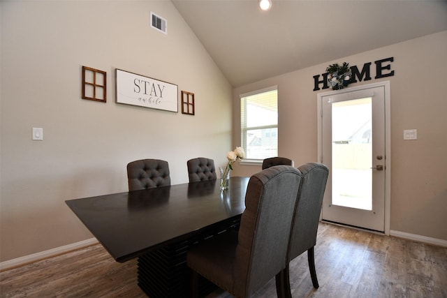 dining room with wood finished floors, baseboards, and lofted ceiling