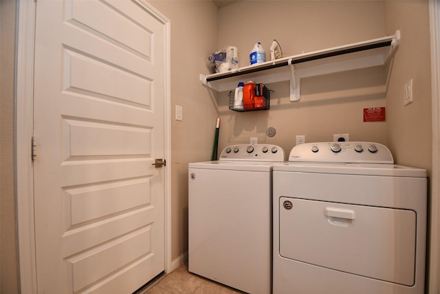 washroom with washing machine and dryer and light tile patterned flooring
