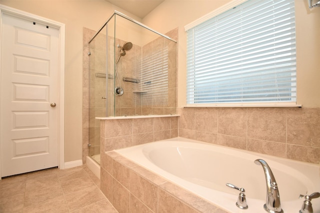 full bathroom with a shower stall, a garden tub, healthy amount of natural light, and tile patterned floors