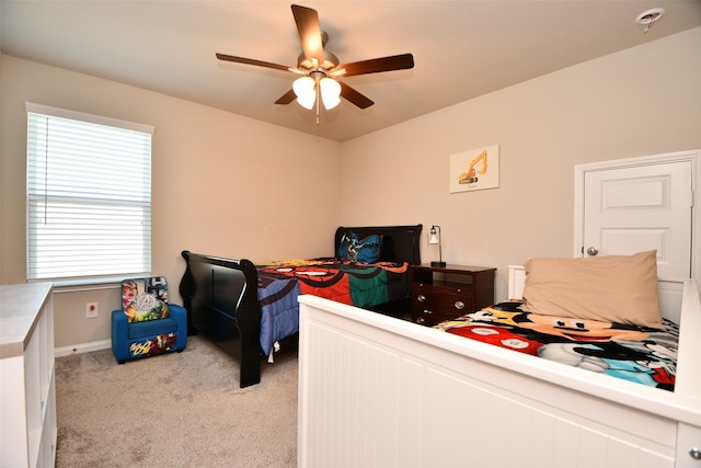 bedroom with light carpet, a ceiling fan, and baseboards