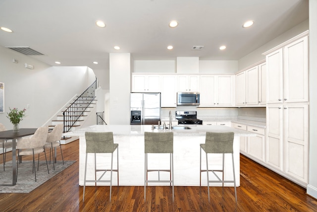 2909 Pease St, Houston, TX 77003 - kitchen featuring appliances with stainless steel finishes, a sink, a kitchen island with sink, a kitchen breakfast bar, and recessed lighting