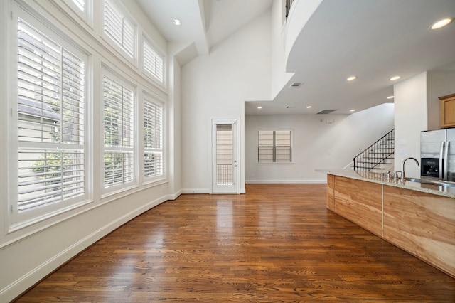 2909 Pease St, Houston, TX 77003 - living area with dark wood-type flooring, stairway, healthy amount of natural light, baseboards, and a high ceiling