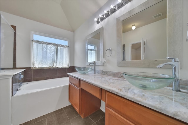 2526 Wood Park Blvd, Conroe, TX 77304 - bathroom featuring double vanity, vaulted ceiling, a bath, and tile patterned floors