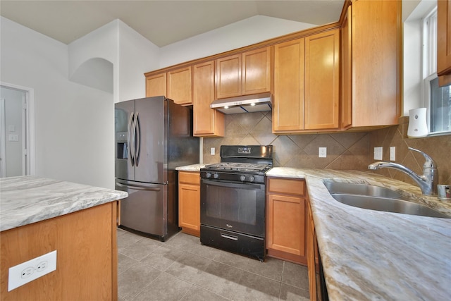 2526 Wood Park Blvd, Conroe, TX 77304 - kitchen with black gas stove, under cabinet range hood, stainless steel refrigerator with ice dispenser, a sink, and light tile patterned floors