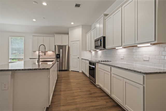177 Jim Hall Ln, New Waverly, TX 77358 - kitchen featuring stainless steel appliances, recessed lighting, white cabinetry, stone counters, and dark wood-style floors