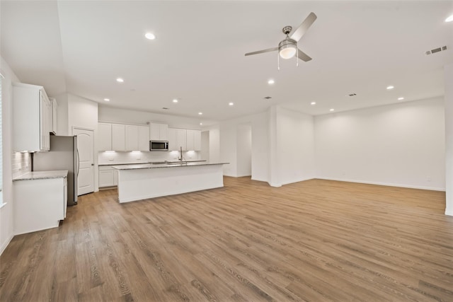 177 Jim Hall Ln, New Waverly, TX 77358 - unfurnished living room with light wood-type flooring, recessed lighting, and ceiling fan
