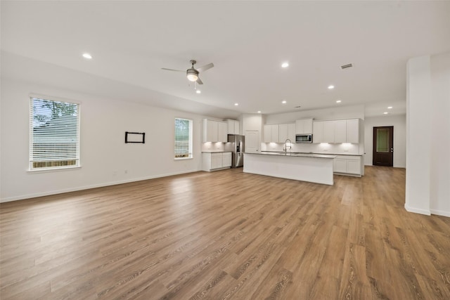 177 Jim Hall Ln, New Waverly, TX 77358 - unfurnished living room with plenty of natural light, light wood-style floors, recessed lighting, and ceiling fan