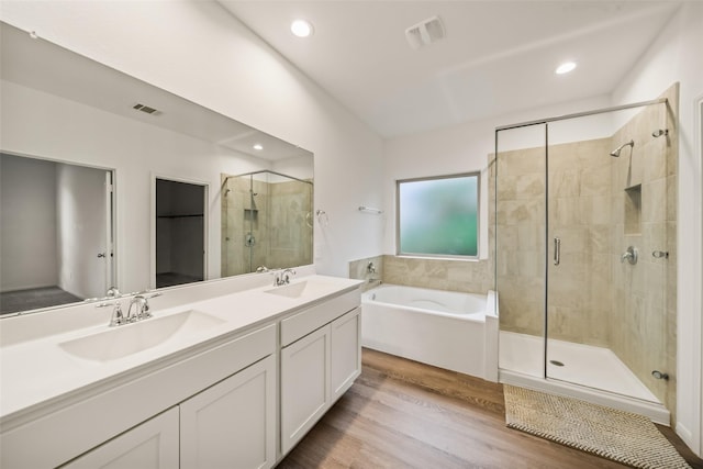 177 Jim Hall Ln, New Waverly, TX 77358 - bathroom featuring a stall shower, a garden tub, double vanity, wood finished floors, and recessed lighting