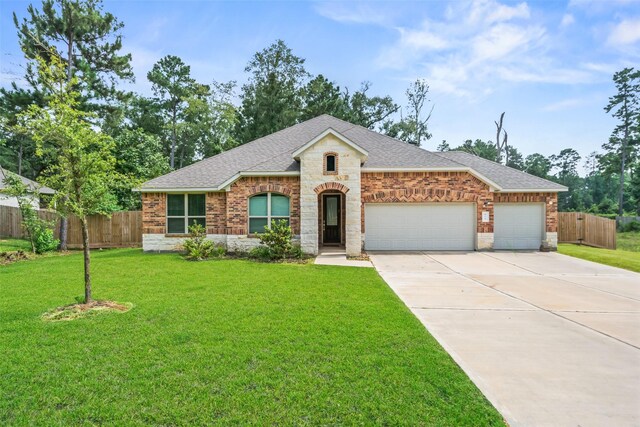 177 Jim Hall Ln, New Waverly, TX 77358 - view of front of property with a shingled roof, driveway, a garage, brick siding, and stone siding