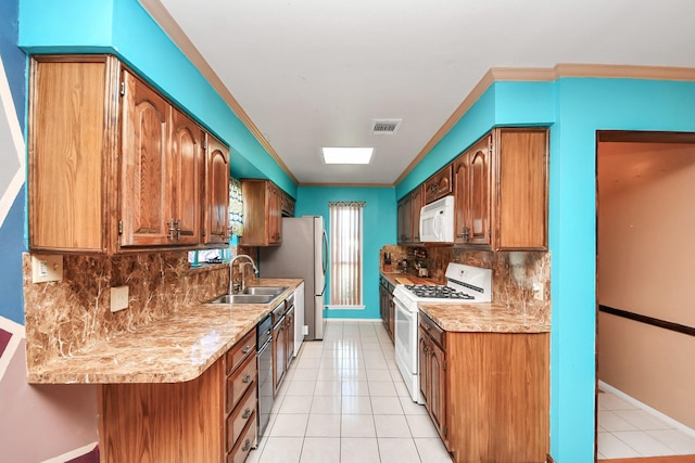 14518 Littleford St, Houston, TX 77045 - kitchen featuring white appliances, a sink, tasteful backsplash, light countertops, and baseboards