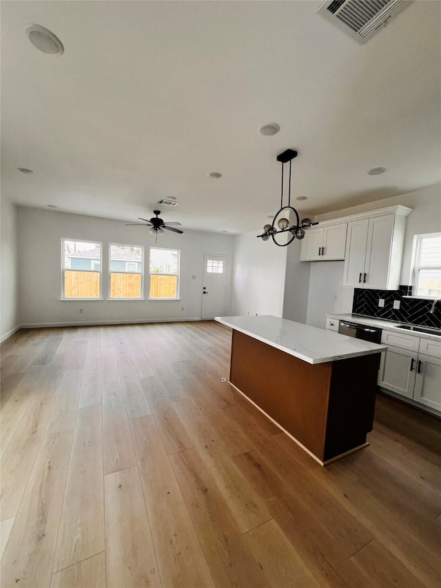 7931 Fields St, Houston, TX 77028 - kitchen featuring open floor plan, white cabinets, healthy amount of natural light, and a kitchen island