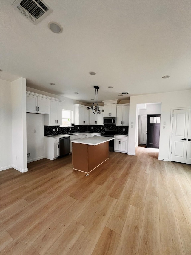 7931 Fields St, Houston, TX 77028 - kitchen featuring dishwashing machine, stainless steel microwave, a center island, and decorative backsplash