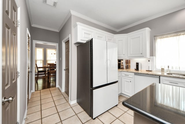 14011 Blazey Dr, Houston, TX 77095 - kitchen with freestanding refrigerator, stainless steel dishwasher, light tile patterned flooring, white cabinets, and crown molding