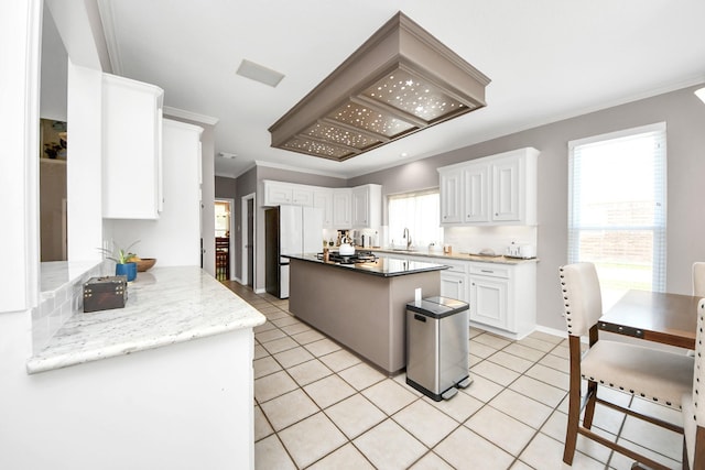14011 Blazey Dr, Houston, TX 77095 - kitchen with a sink, freestanding refrigerator, white cabinetry, light tile patterned floors, and crown molding