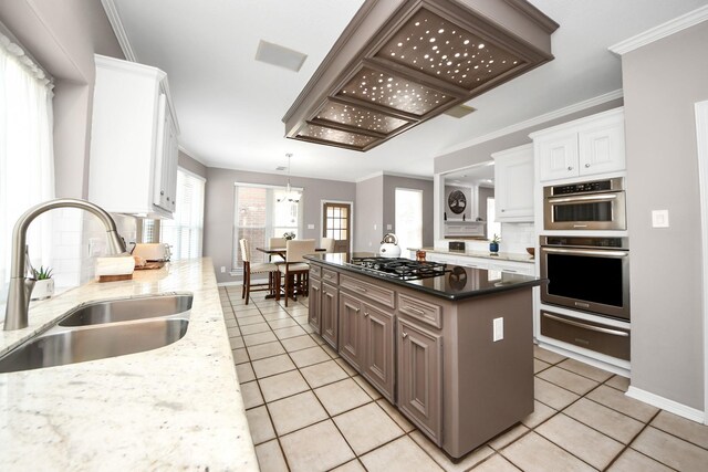 14011 Blazey Dr, Houston, TX 77095 - kitchen featuring a warming drawer, a sink, appliances with stainless steel finishes, light tile patterned flooring, and crown molding