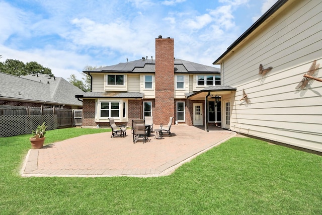 14011 Blazey Dr, Houston, TX 77095 - back of property featuring brick siding, a chimney, roof mounted solar panels, and a patio