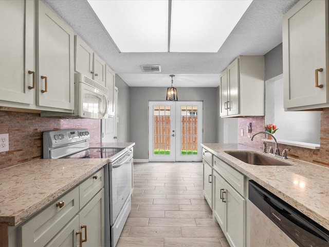 11731 Flushing Meadows Dr, Houston, TX 77089 - kitchen with white appliances, a sink, decorative backsplash, light stone counters, and a textured ceiling