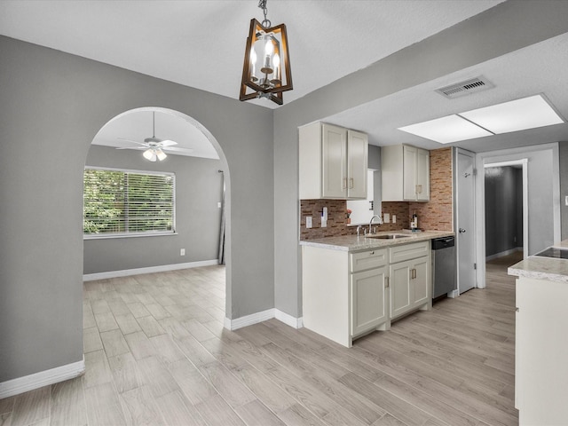 11731 Flushing Meadows Dr, Houston, TX 77089 - kitchen with arched walkways, a sink, dishwasher, decorative backsplash, and baseboards