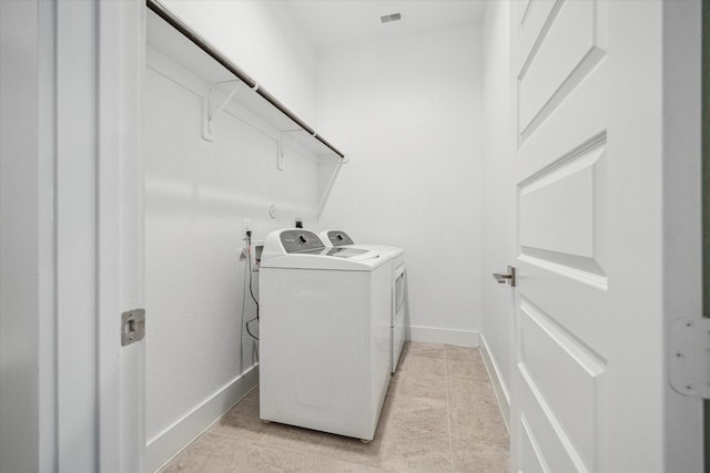 10022 Waving Grain Ln, Houston, TX 77080 - laundry room featuring washer and dryer, light tile patterned floors, and baseboards