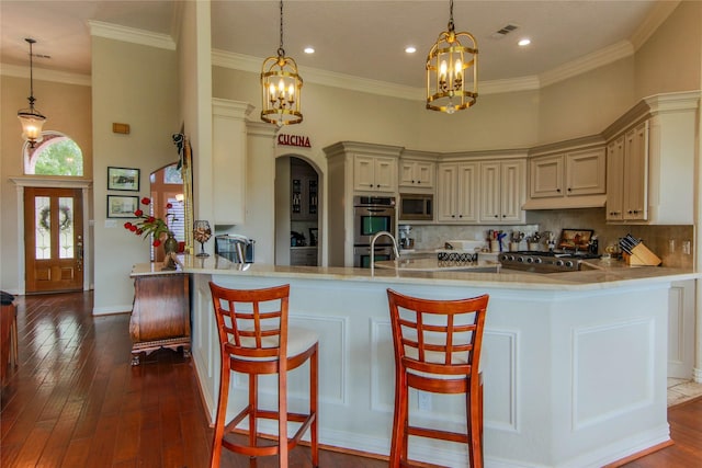 107 Edgewood Dr, Montgomery, TX 77356 - kitchen with appliances with stainless steel finishes, a chandelier, a high ceiling, tasteful backsplash, and ornamental molding