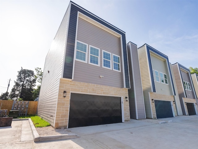 825 Paul Quinn St Unit E, Houston, TX 77091 - contemporary house with a garage, driveway, and stone siding