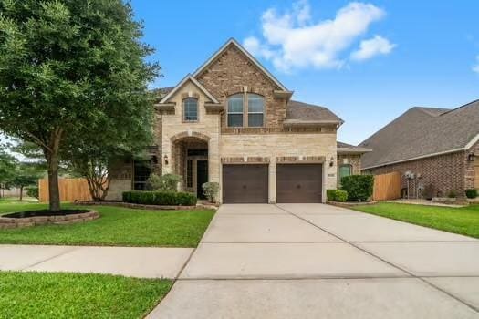 27303 Balson Forest Ln, Spring, TX 77386 - view of front of property with driveway, stone siding, and a garage