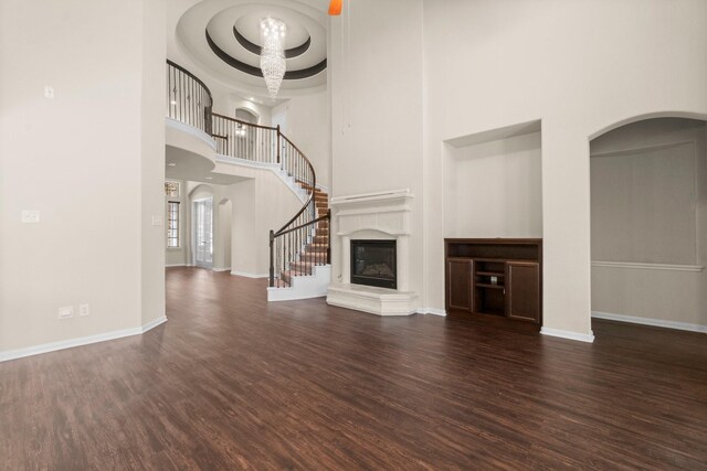 27303 Balson Forest Ln, Spring, TX 77386 - unfurnished living room featuring a high ceiling, wood finished floors, stairway, baseboards, and a glass covered fireplace