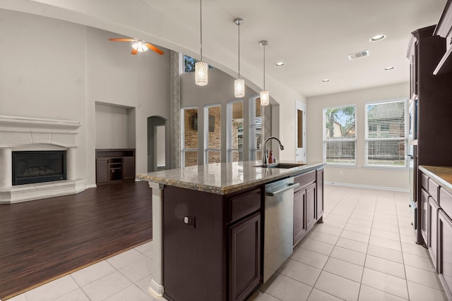 27303 Balson Forest Ln, Spring, TX 77386 - kitchen featuring a sink, stainless steel dishwasher, light tile patterned floors, dark brown cabinets, and open floor plan