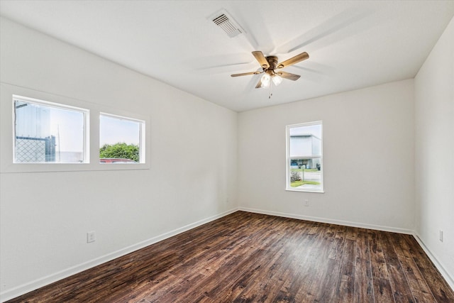 701 Malone St, Tomball, TX 77375 - empty room featuring plenty of natural light, dark wood-style floors, ceiling fan, and baseboards