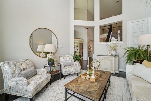 13710 Nubenbrook Lake Dr, Houston, TX 77044 - living area with arched walkways, wood finished floors, a towering ceiling, and baseboards
