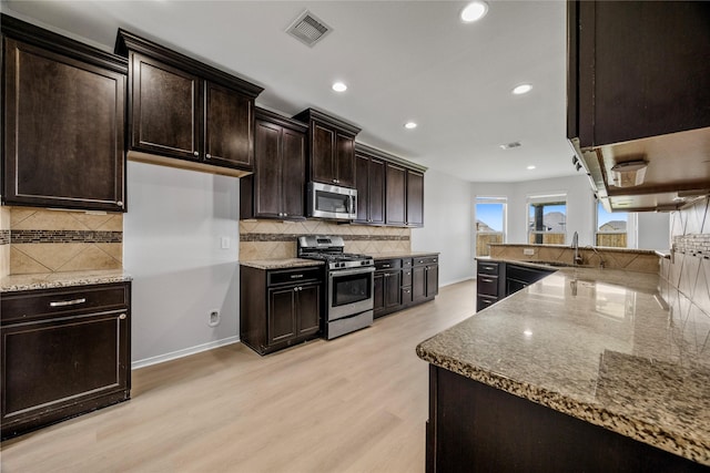 11915 Eagle Ridge Dr, Mont Belvieu, TX 77535 - kitchen with stainless steel appliances, stone counters, decorative backsplash, and recessed lighting