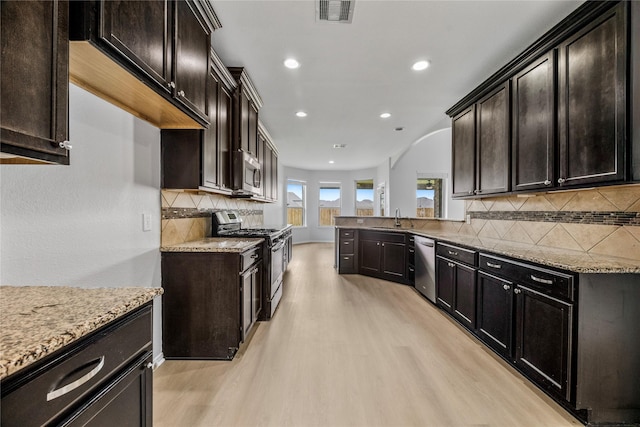 11915 Eagle Ridge Dr, Mont Belvieu, TX 77535 - kitchen featuring appliances with stainless steel finishes, a sink, light wood-type flooring, light stone counters, and recessed lighting