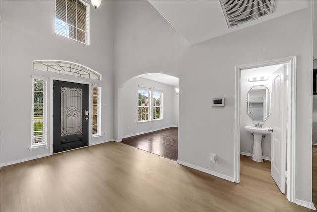 11915 Eagle Ridge Dr, Mont Belvieu, TX 77535 - entryway featuring arched walkways, a high ceiling, wood finished floors, and baseboards