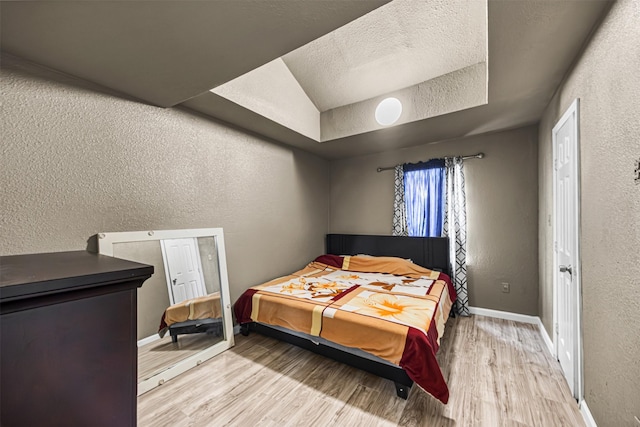 12910 Green River Dr, Houston, TX 77044 - bedroom featuring a textured wall, wood finished floors, baseboards, and a textured ceiling