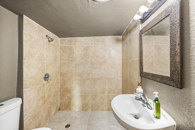 12910 Green River Dr, Houston, TX 77044 - bathroom with tiled shower, a sink, a textured ceiling, and toilet