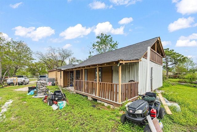 12910 Green River Dr, Houston, TX 77044 - view of side of property with roof with shingles, board and batten siding, covered porch, and a lawn