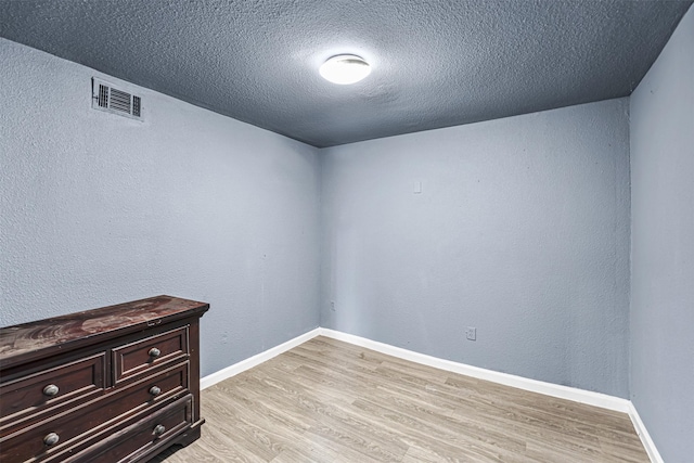 12910 Green River Dr, Houston, TX 77044 - spare room with a textured ceiling, light wood finished floors, baseboards, and a textured wall