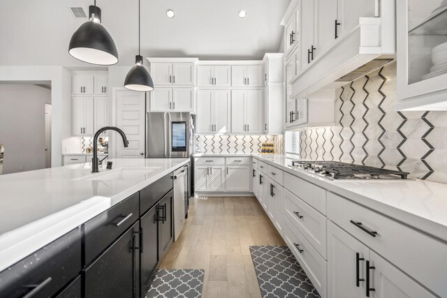 24515 Green Buffalograss Trl, Katy, TX 77493 - kitchen with white cabinets, stainless steel appliances, dark cabinets, a sink, and pendant lighting