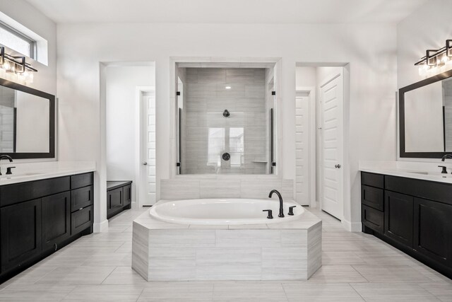 24515 Green Buffalograss Trl, Katy, TX 77493 - bathroom with a garden tub, two vanities, a tile shower, baseboards, and tile patterned flooring